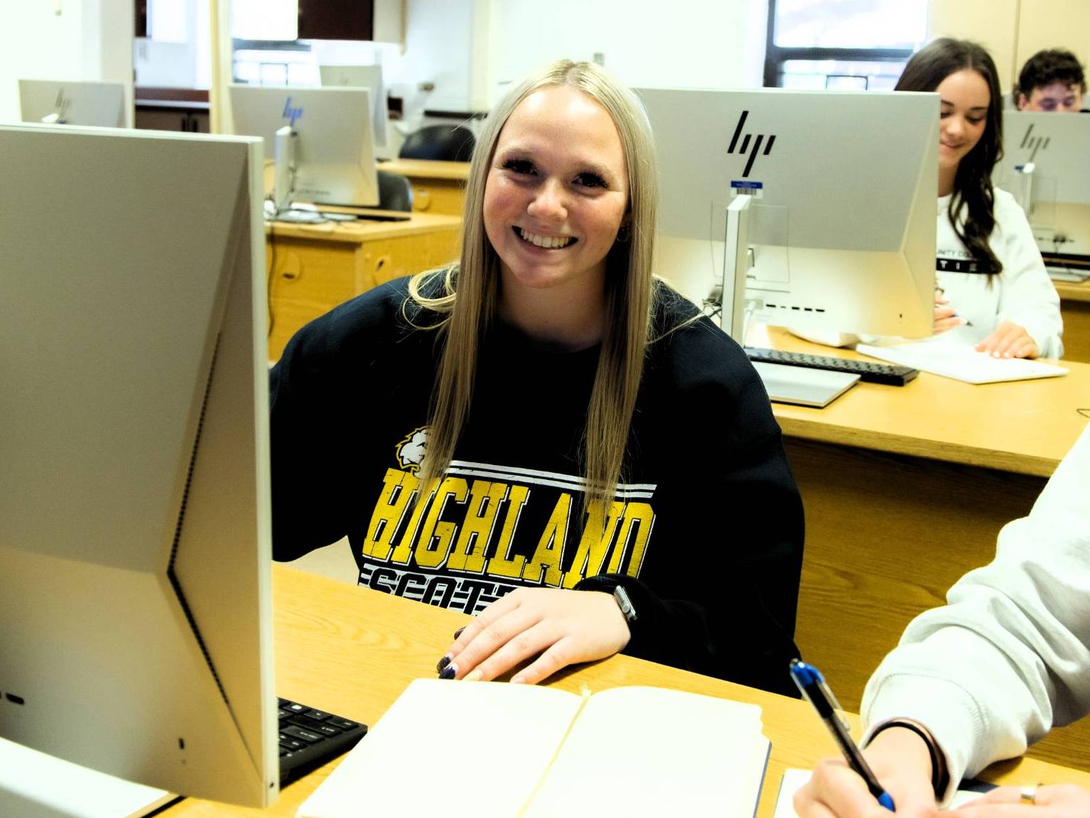 Student using the computer lab smiles at the camera