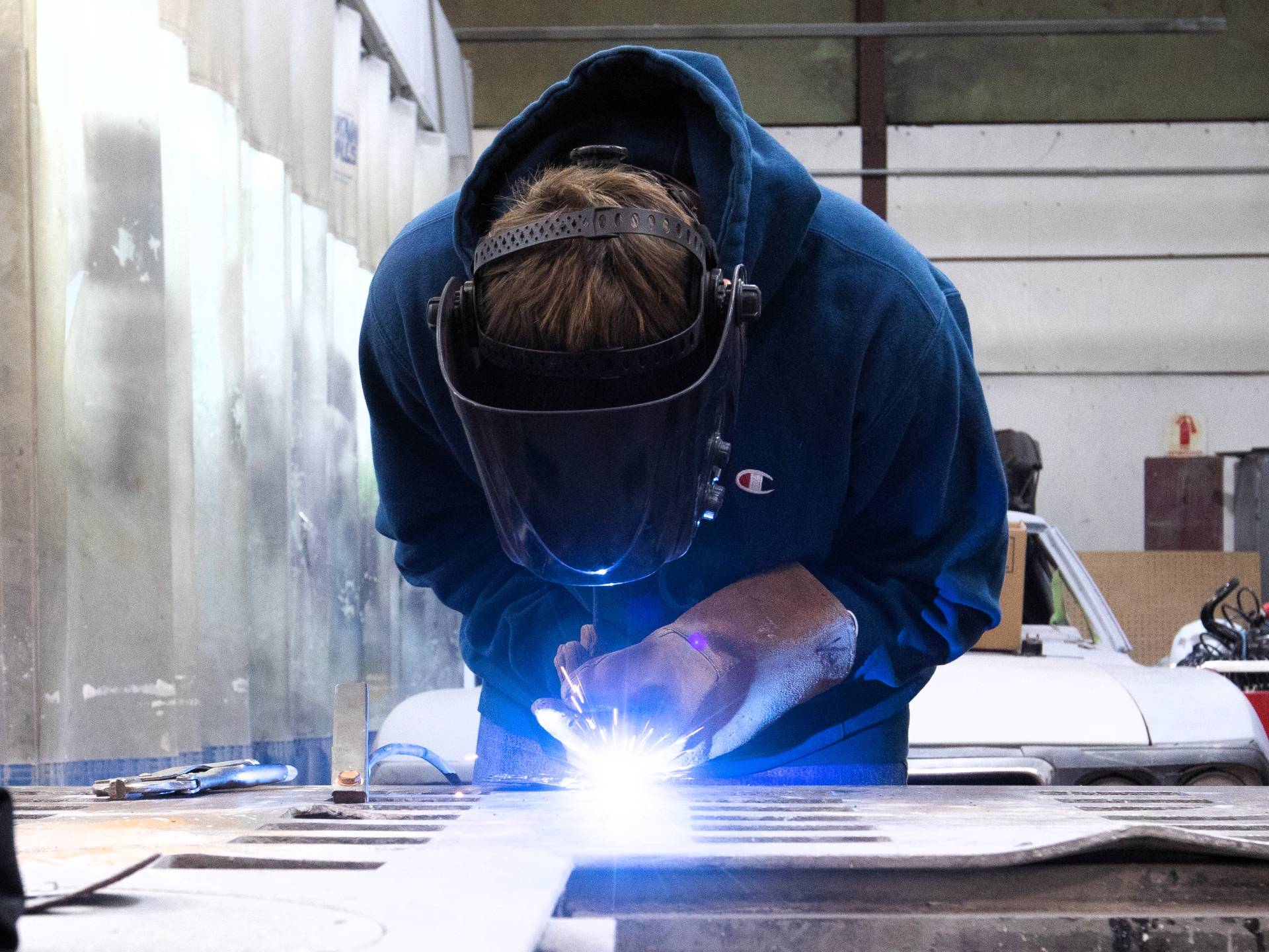 Welding student is working on a piece of equipment 