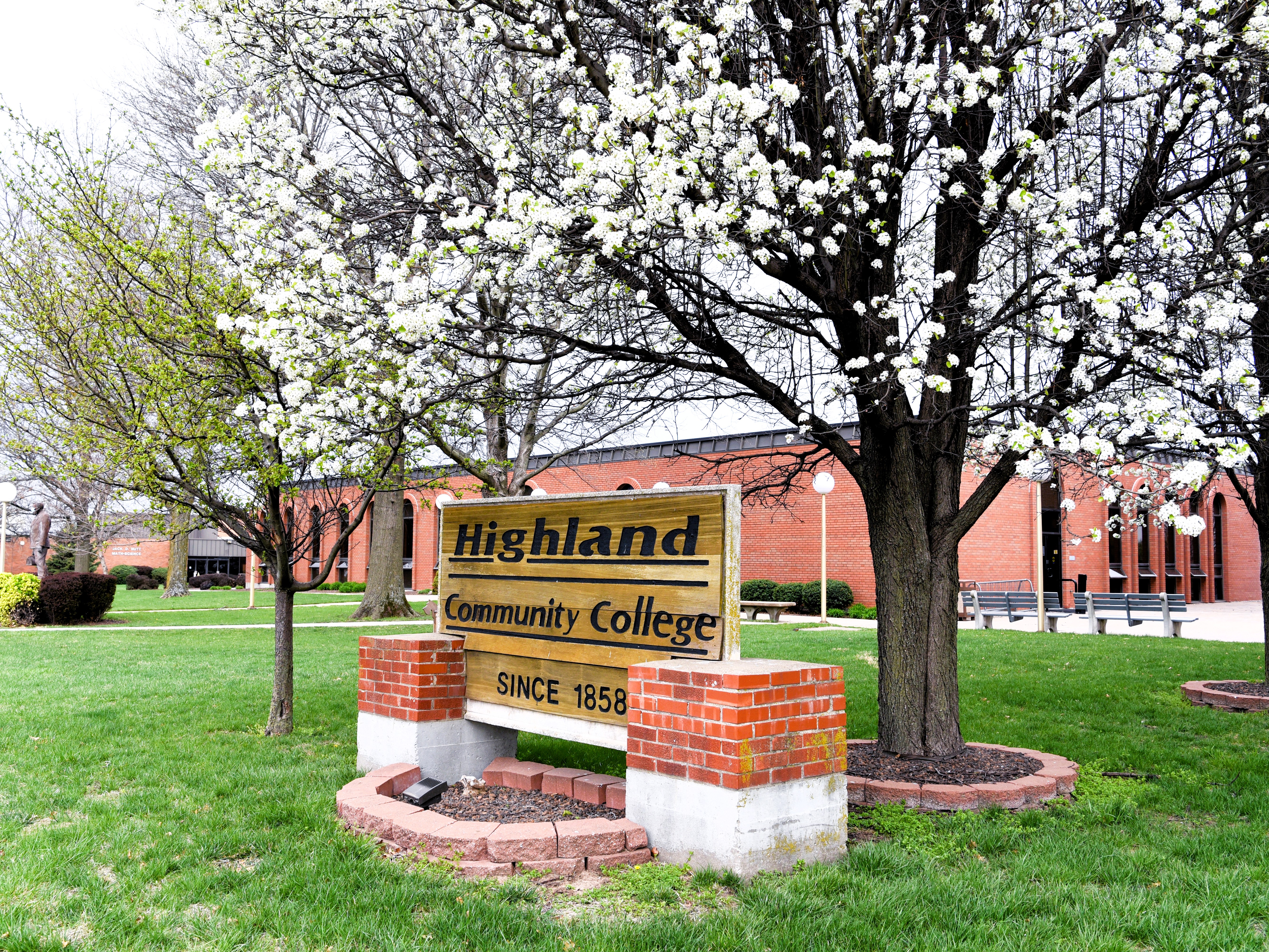 Spring Time on the Highland Campus with a view of the Highland CC sign and trees starting to bud. 