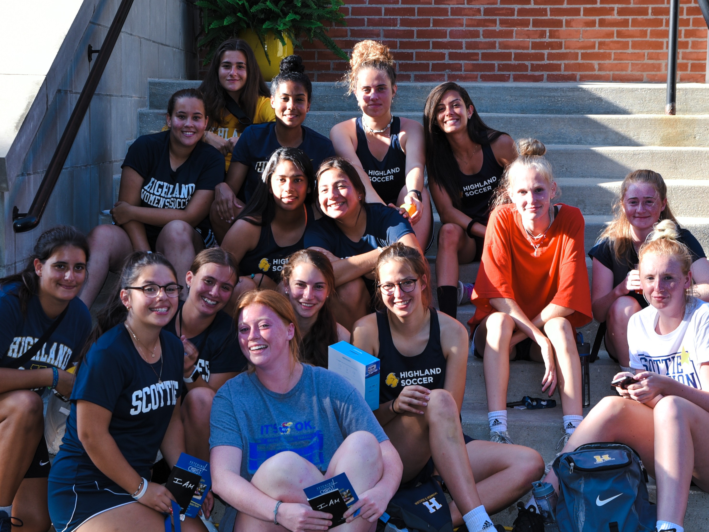 Women's Soccer team poses together on the front steps of the administration building.