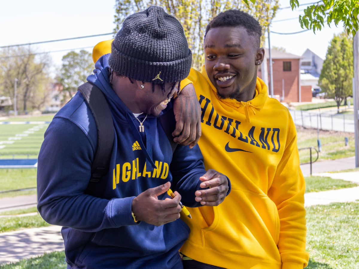 Two students outside laughing together